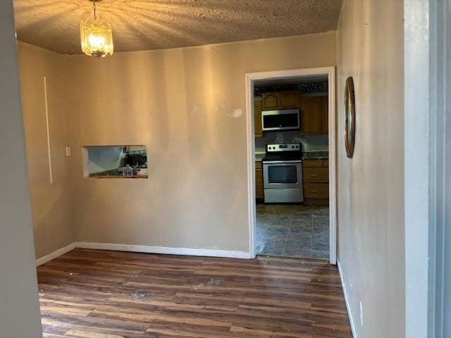 spare room with dark hardwood / wood-style floors and a textured ceiling