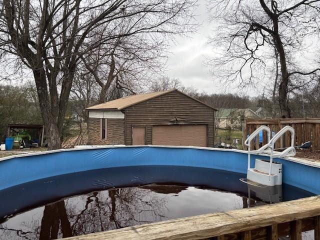 view of pool featuring an outbuilding and a garage