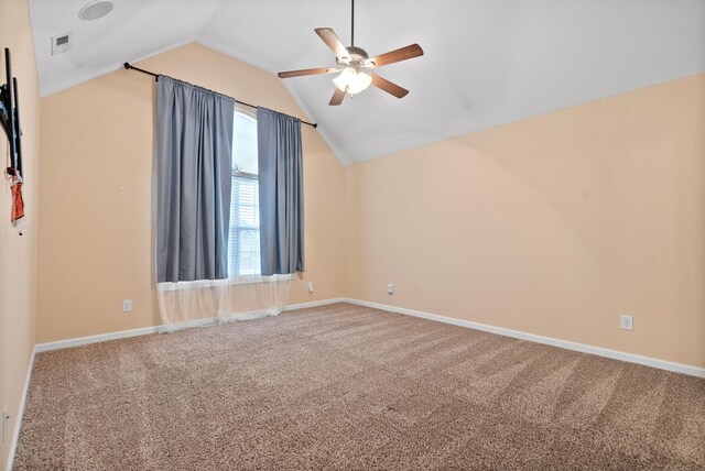 spare room featuring vaulted ceiling, carpet flooring, and ceiling fan