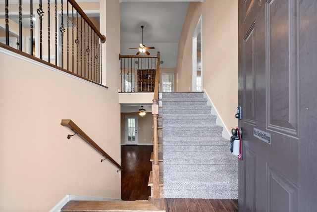 entrance foyer with ceiling fan, a towering ceiling, and dark hardwood / wood-style flooring