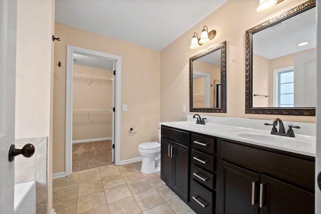 bathroom with vanity, a tub to relax in, tile patterned floors, and toilet