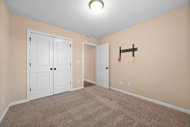 unfurnished bedroom with a closet, a textured ceiling, and carpet