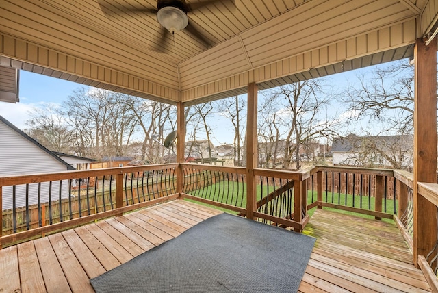 wooden terrace featuring a lawn and ceiling fan