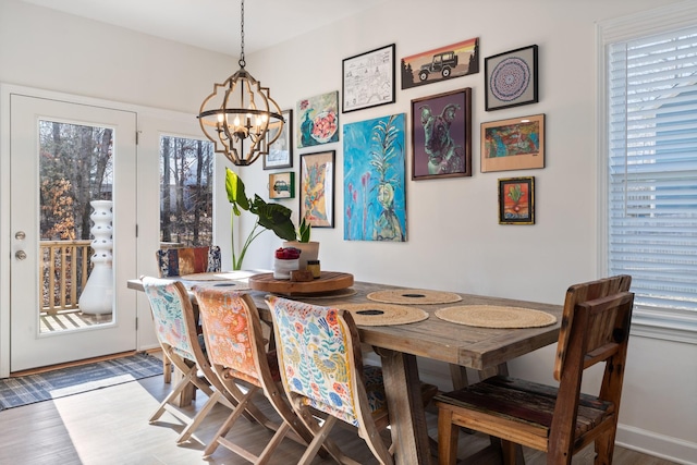 dining space with hardwood / wood-style flooring and a chandelier