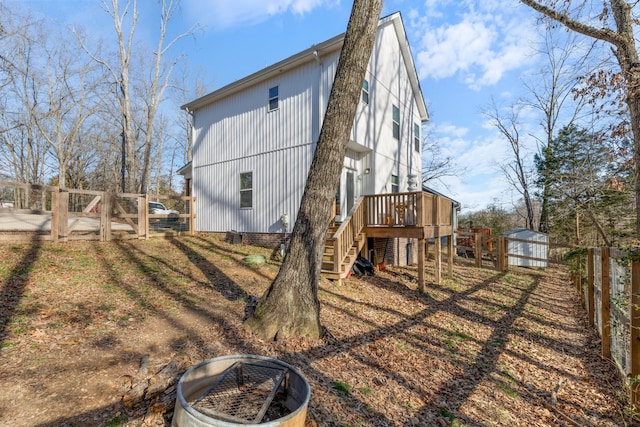 back of house featuring a wooden deck and an outdoor fire pit