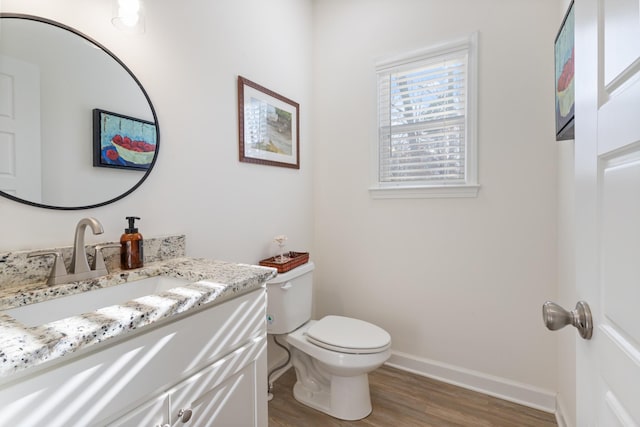 bathroom with hardwood / wood-style flooring, vanity, and toilet