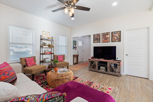 living room featuring ceiling fan and light hardwood / wood-style floors