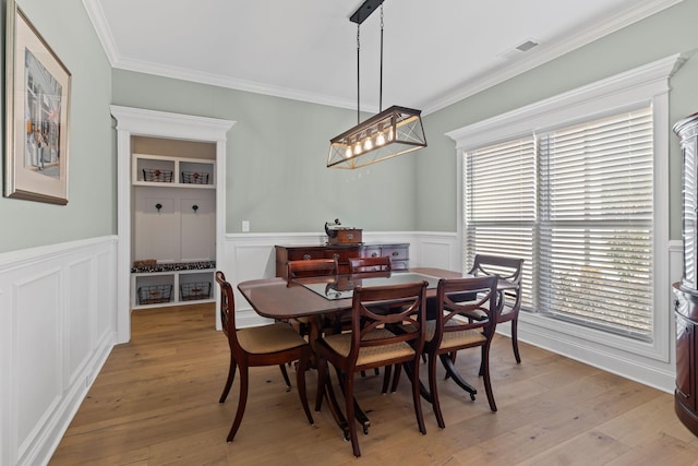 dining room featuring light hardwood / wood-style flooring, crown molding, and plenty of natural light