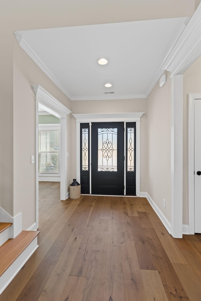 entryway with hardwood / wood-style floors and ornamental molding