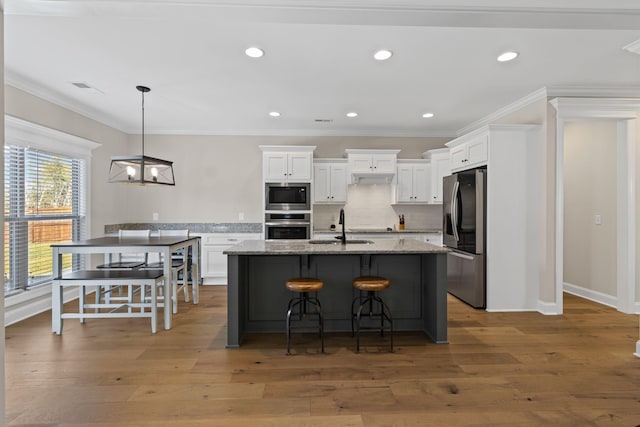 kitchen featuring light stone counters, white cabinetry, stainless steel appliances, and sink