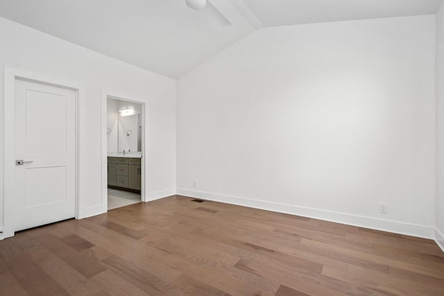 unfurnished bedroom with lofted ceiling, hardwood / wood-style flooring, ceiling fan, and ensuite bathroom