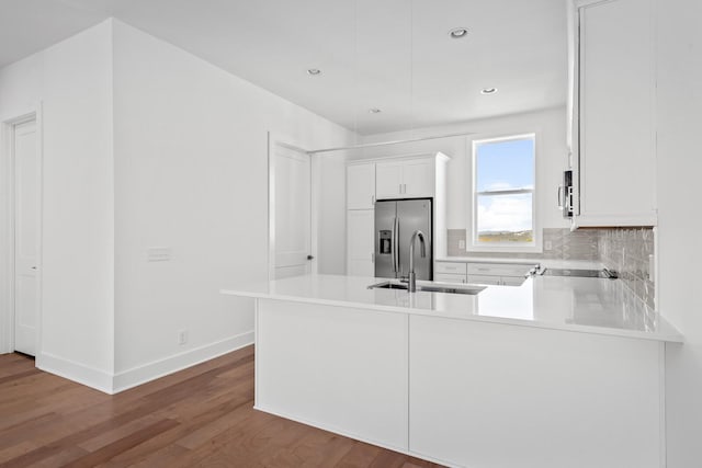 kitchen with white cabinetry, sink, kitchen peninsula, and appliances with stainless steel finishes