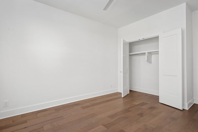 unfurnished bedroom with dark hardwood / wood-style floors, ceiling fan, and a closet