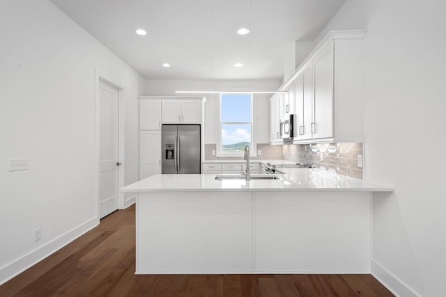 kitchen featuring white cabinetry, sink, kitchen peninsula, and appliances with stainless steel finishes