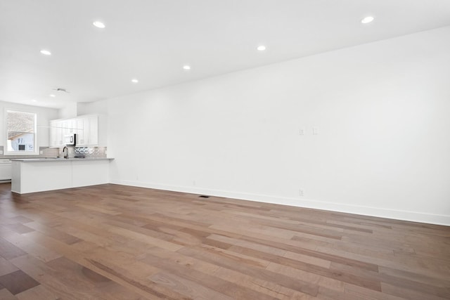 unfurnished living room featuring sink and light wood-type flooring