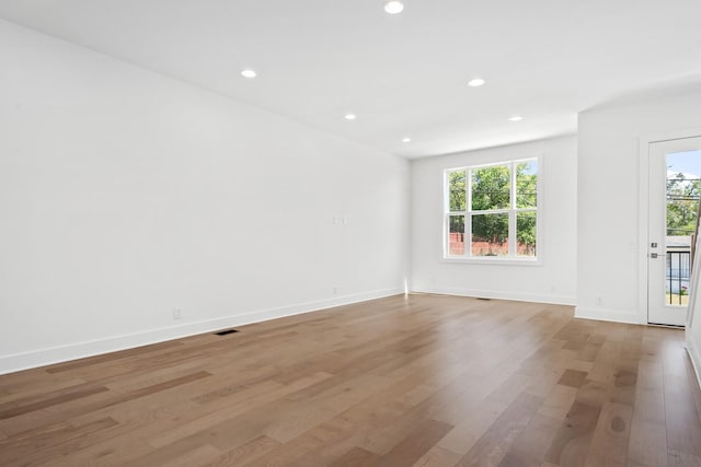 empty room with light wood-type flooring and a wealth of natural light