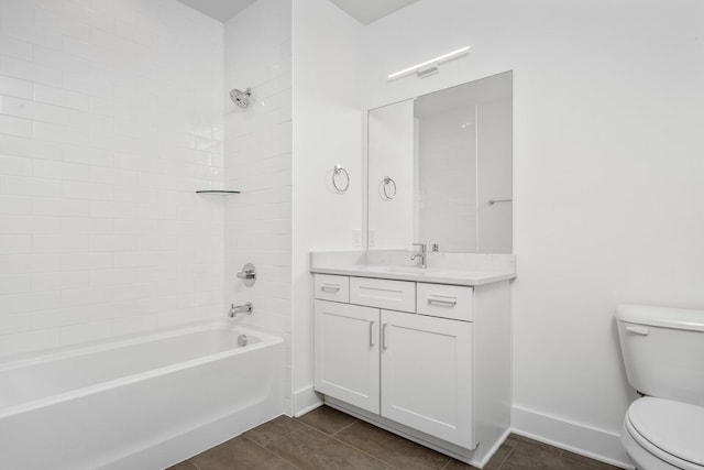 full bathroom featuring tiled shower / bath, vanity, tile patterned floors, and toilet