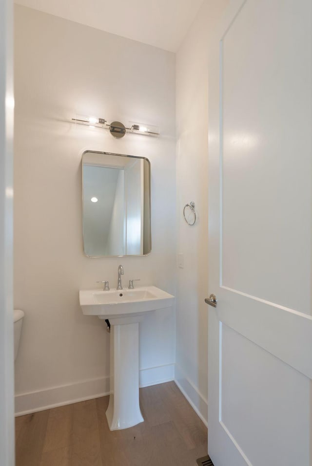 bathroom featuring hardwood / wood-style floors and toilet