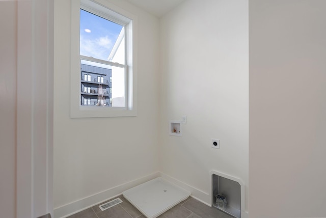 clothes washing area with hookup for an electric dryer, hookup for a washing machine, and dark tile patterned floors