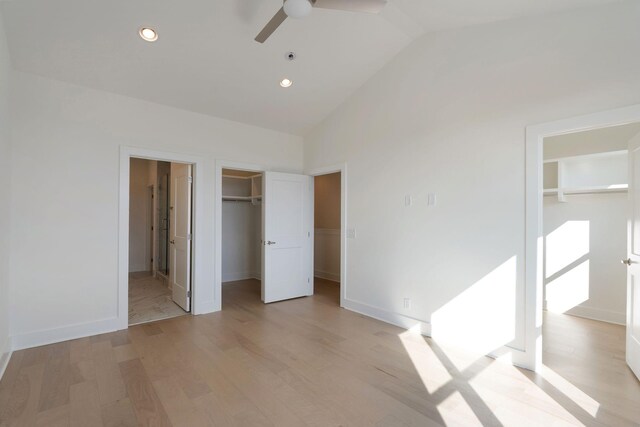 unfurnished bedroom featuring high vaulted ceiling, a spacious closet, light hardwood / wood-style floors, and ceiling fan