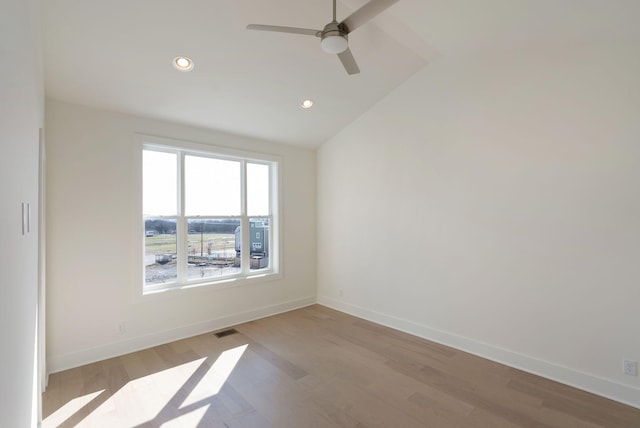 spare room featuring vaulted ceiling, ceiling fan, and light wood-type flooring