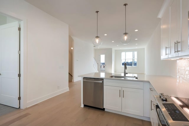 kitchen featuring appliances with stainless steel finishes, decorative light fixtures, sink, white cabinets, and kitchen peninsula