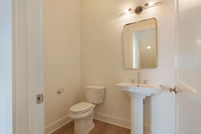 bathroom with sink, toilet, and hardwood / wood-style floors