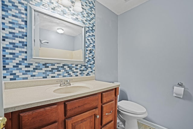 bathroom with vanity, backsplash, and toilet