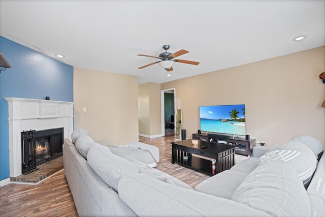 living room featuring wood-type flooring and ceiling fan