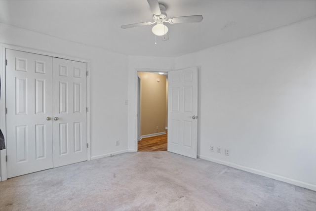 unfurnished bedroom with ceiling fan, a closet, and light carpet