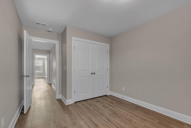 unfurnished bedroom featuring a closet and light hardwood / wood-style flooring