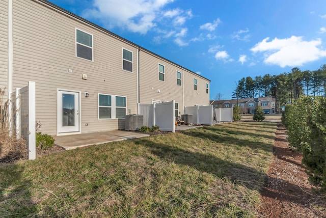 rear view of house featuring cooling unit, a patio area, and a lawn