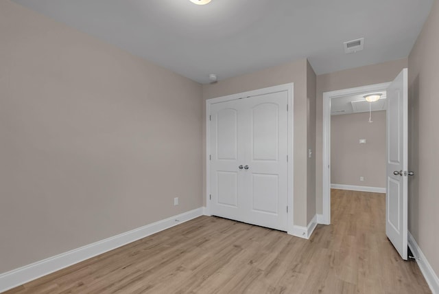 unfurnished bedroom featuring a closet and light wood-type flooring