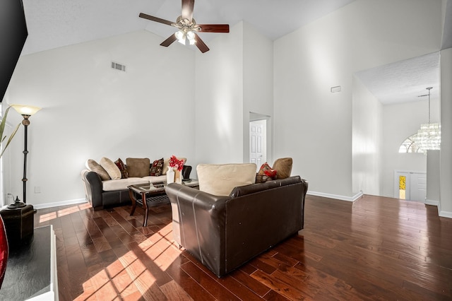 living room featuring ceiling fan with notable chandelier, dark wood-type flooring, and high vaulted ceiling