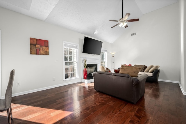 living room featuring a textured ceiling, high vaulted ceiling, dark hardwood / wood-style floors, and ceiling fan