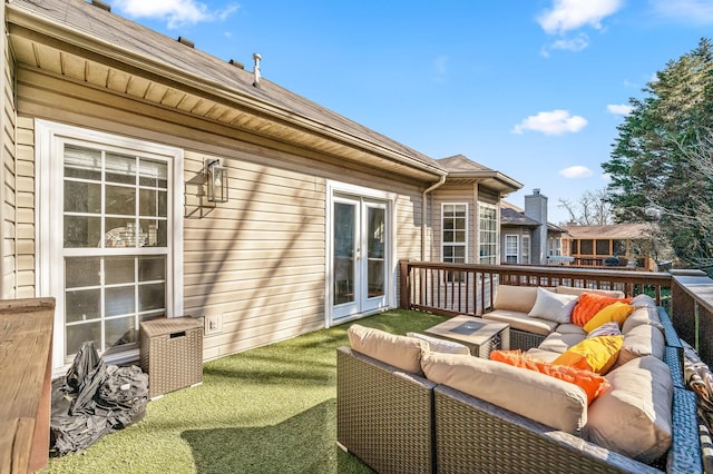 wooden terrace featuring an outdoor living space, a yard, and french doors