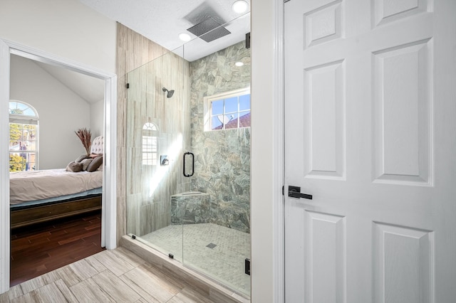 bathroom featuring lofted ceiling and a shower with shower door