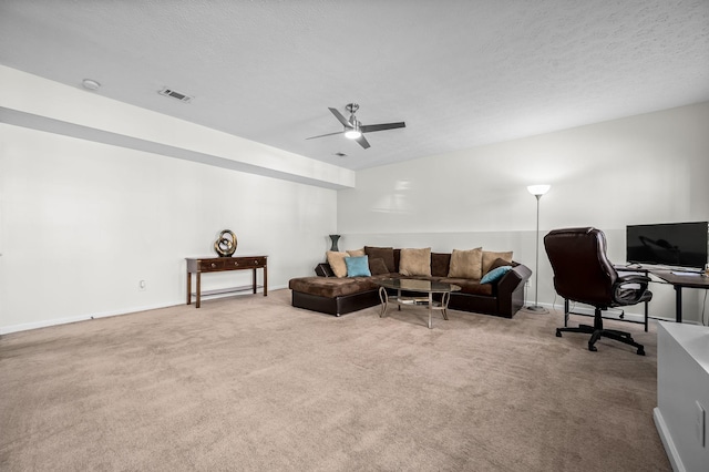 living room featuring ceiling fan, light colored carpet, and a textured ceiling