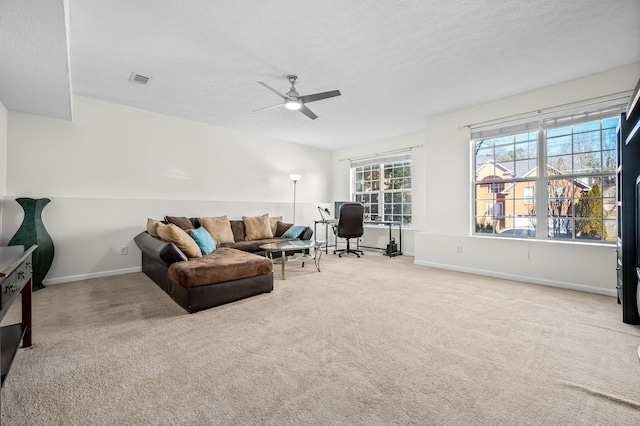 carpeted living room featuring ceiling fan and a textured ceiling