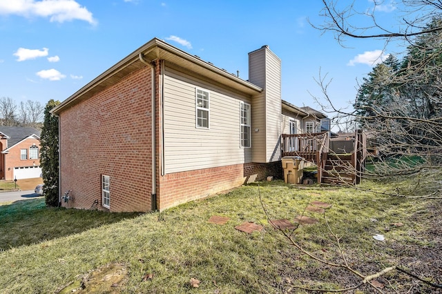 view of home's exterior featuring a wooden deck and a lawn