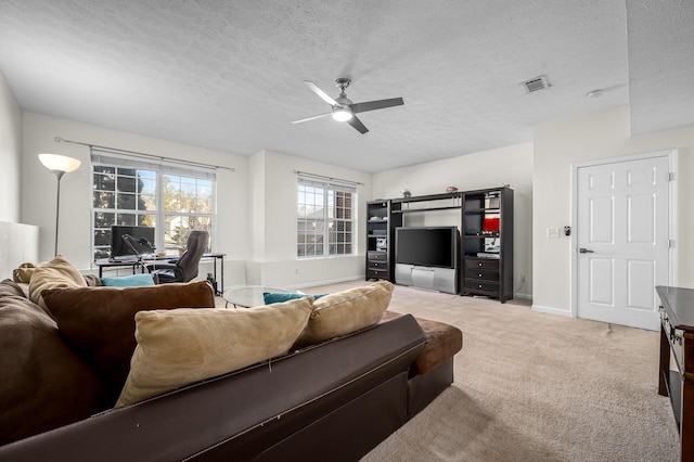 carpeted living room with ceiling fan and a textured ceiling