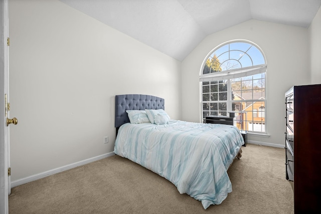 bedroom with light colored carpet and lofted ceiling