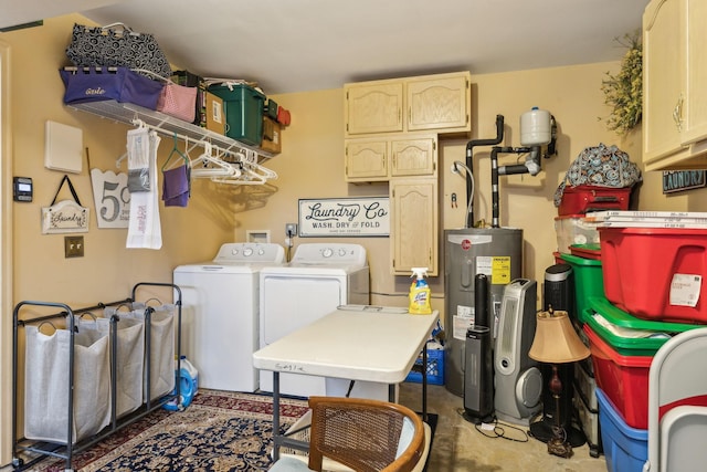 clothes washing area with cabinets, independent washer and dryer, and water heater