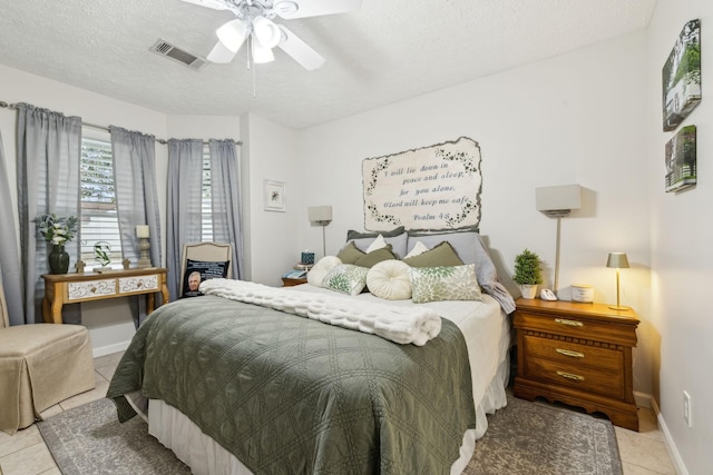 tiled bedroom featuring ceiling fan and a textured ceiling