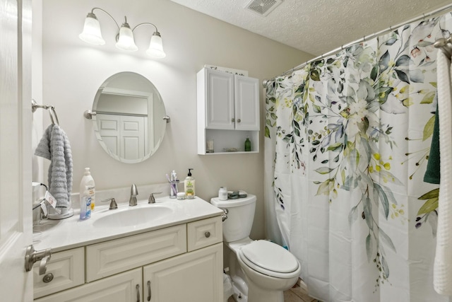 bathroom featuring vanity, curtained shower, a textured ceiling, and toilet