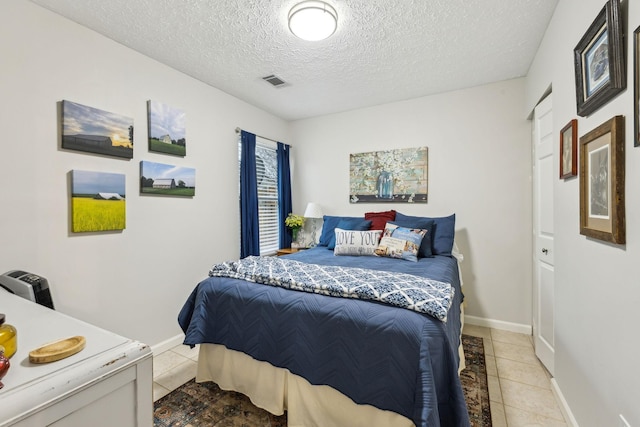 tiled bedroom featuring a textured ceiling