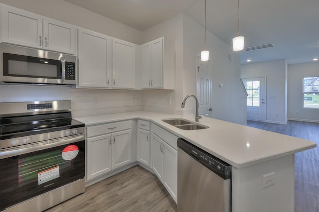 kitchen featuring white cabinetry, appliances with stainless steel finishes, and kitchen peninsula