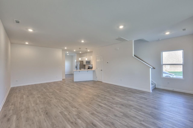 unfurnished living room featuring light wood-type flooring