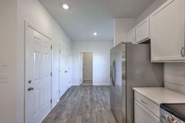 kitchen featuring light hardwood / wood-style flooring, stainless steel appliances, and white cabinets