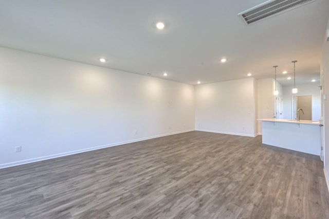 unfurnished room featuring sink and dark hardwood / wood-style floors